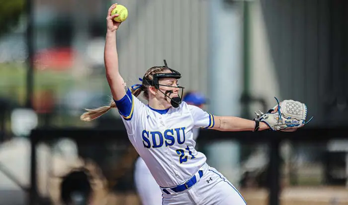 Softball player mid pitch